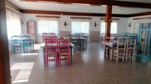 a dining room with red chairs and tables in a room at Rural Sant Llop in Tordera