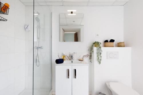 y baño blanco con lavabo y ducha. en Centre studio plage et festival en Cannes