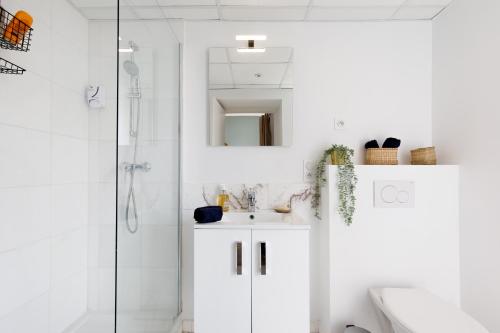 une salle de bain blanche avec un lavabo et une douche dans l'établissement Centre studio plage et festival, à Cannes