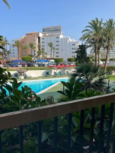 uma vista para uma piscina com palmeiras e edifícios em Entremares estudio a 150 metros playa em Roquetas de Mar