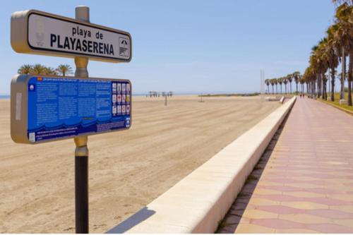 a street sign on the beach next to a beach at Entremares estudio a 150 metros playa in Roquetas de Mar