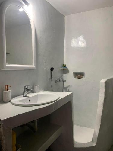 a white bathroom with a sink and a shower at Volcano View Nisyros in Mandrákion