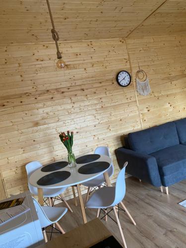 a living room with a table and chairs and a couch at Casutele din Poienita in Comarnic