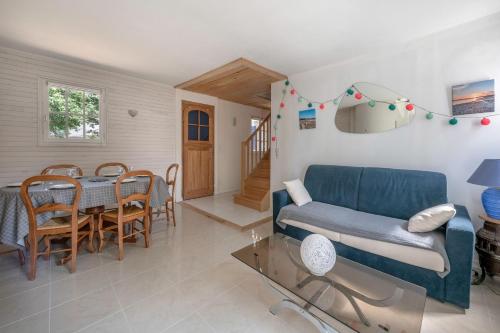 un salon avec un canapé bleu et une table dans l'établissement Escapade au calme et près de la plage, à Assérac