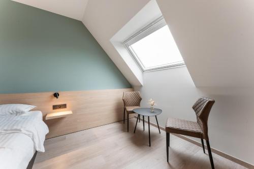 a bedroom with a bed and a table and chairs at Hof Ter Molen - Luxe kamer met privé badkamer in Diksmuide
