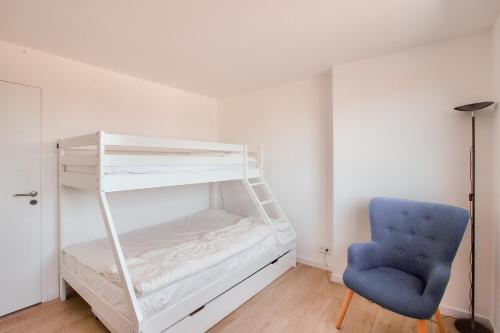 ein Schlafzimmer mit einem Etagenbett und einem blauen Stuhl in der Unterkunft Villa neuve avec piscine vue sur mer pour 9 in Pléneuf-Val-André