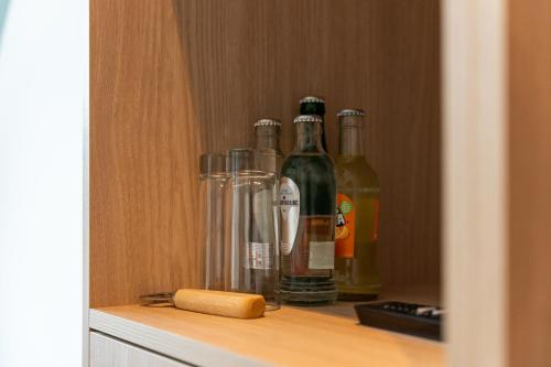 a cabinet with bottles of alcohol on a shelf at Hof Ter Molen - Luxe kamer met privé badkamer in Diksmuide