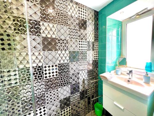 a bathroom with a shower with a sink and a mirror at Glaz Ocean in Douarnenez
