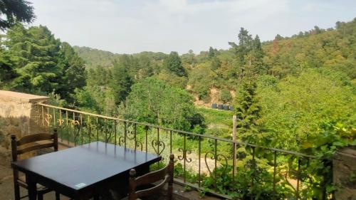 a table on a balcony with a view of a forest at Rural Sant Llop in Tordera