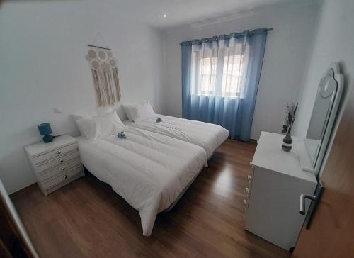 a bedroom with a bed and a dresser and a window at Casa da Avo dos Anjos in Casais de São Mamede