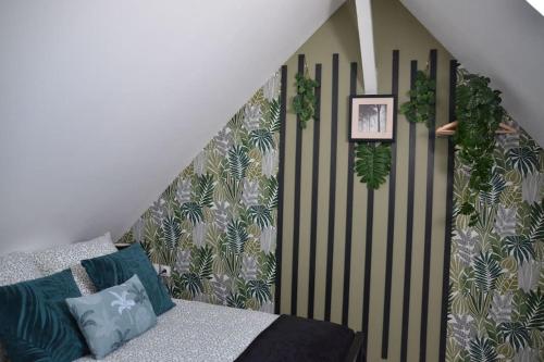 a room with a bed with plants on the wall at Un cocon en centre-ville in Roye