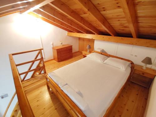 an attic bedroom with a bed and a ladder at Olive Garden Loft Apartment in Kokkari