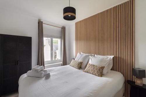 una camera da letto con un grande letto bianco e una finestra di La Maison de Louise - Superbe maison avec patio a Cancale