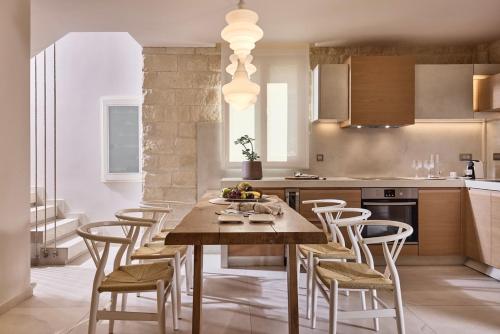 une cuisine avec une table et des chaises en bois dans l'établissement Melitina, à Siteía