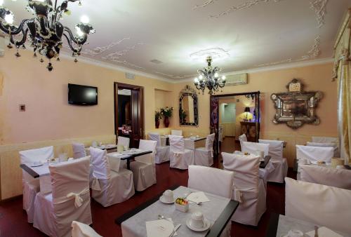 a restaurant with white tables and chairs and a chandelier at Hotel Ca' Alvise in Venice