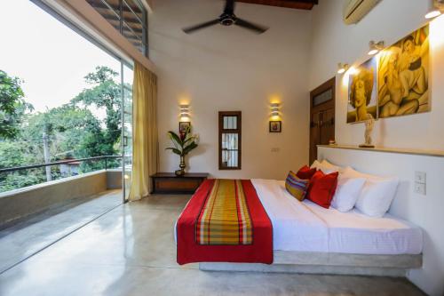 a bedroom with a bed and a large window at Margossa Residence by 55TG in Kandy
