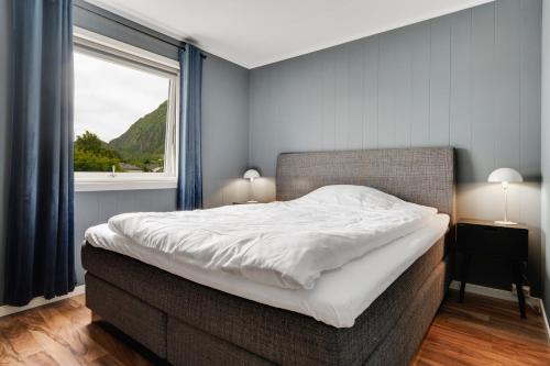 Schlafzimmer mit einem großen Bett und einem Fenster in der Unterkunft Mosjøen Apartments Sentrum in Mosjøen