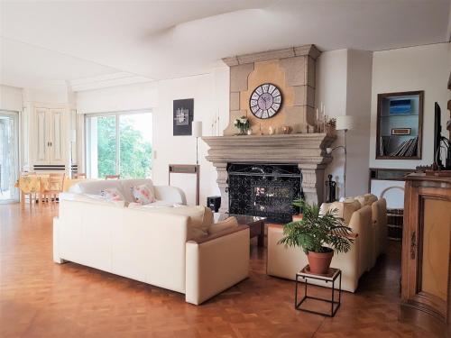 sala de estar con 2 sofás blancos y chimenea en Domaine de la Chesnaie, en Josselin