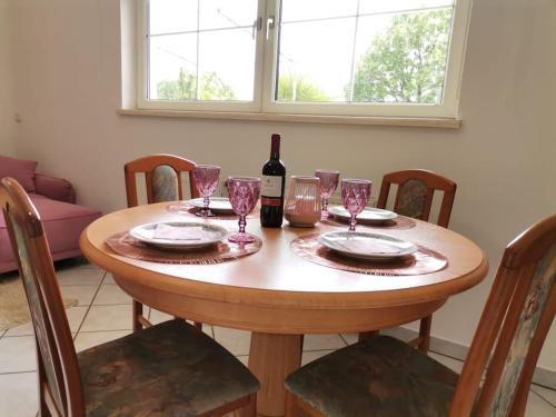 uma mesa de madeira com uma garrafa de vinho e copos em Haus MARE - entspannen & sonnenbaden em Viskovo