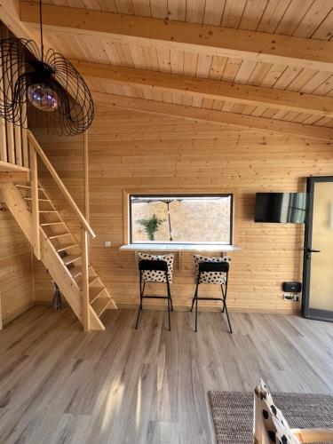 a room with a table and two chairs and a staircase at Wood11 - Charming TinyHouse in a Lovely Garden in Santa Bárbara de Nexe