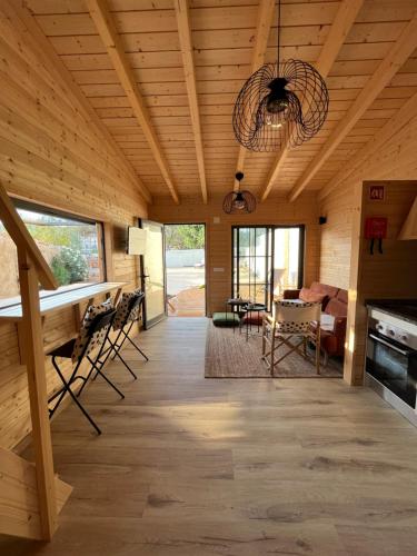 a living room with a wooden ceiling and a dining room at Wood11 - Charming TinyHouse in a Lovely Garden in Santa Bárbara de Nexe