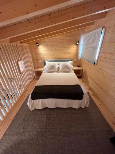 a bedroom with a bed in a wooden room at Wood11 - Charming TinyHouse in a Lovely Garden in Santa Bárbara de Nexe