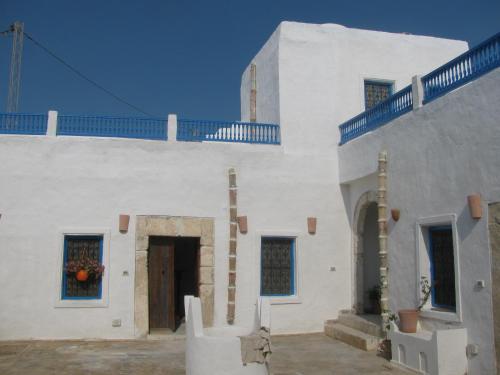 un edificio bianco con una porta e scale sopra di Dar Michèle Djerba a Houmt Souk