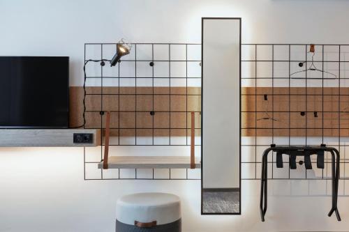 a wall with a mirror and a lamp on it at Moxy Hamburg City in Hamburg