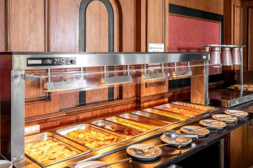 a kitchen with a bunch of trays of food at Kapetanios Limassol Hotel in Limassol