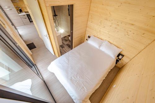 uma vista sobre uma cama num pequeno quarto em Le Laponya - Chalet climatisé avec SPA & Borne de recharge em Bressols