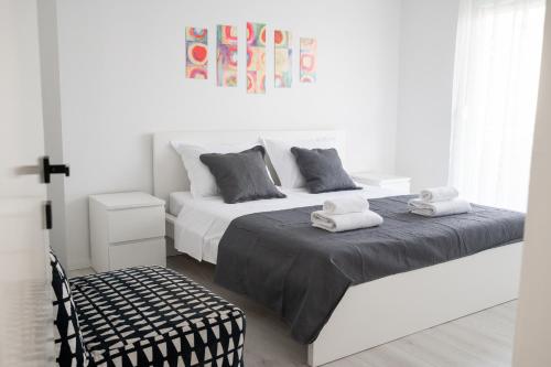 a white bedroom with a bed with towels on it at Apartment Adam in Zadar