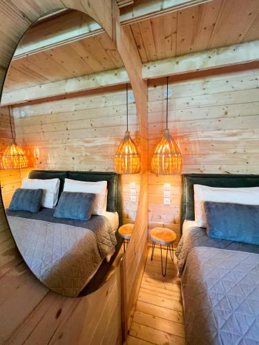 two beds in a room with wooden walls and lights at Elleria's House in Lefkada Town