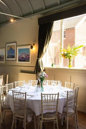 a dining room with a table with chairs and a window at Cliftonville Hotel in Cromer