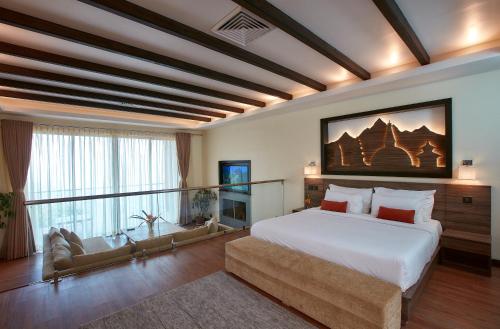 sypialnia z dużym białym łóżkiem i kanapą w obiekcie Dhulikhel Lodge Resort w mieście Dhulikhel