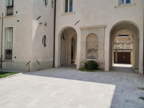 un cortile vuoto di un edificio con archi di Garibaldi Guest House a L'Aquila