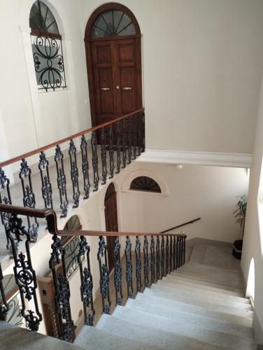 Una escalera en una casa con puerta de madera en Garibaldi Guest House, en LʼAquila