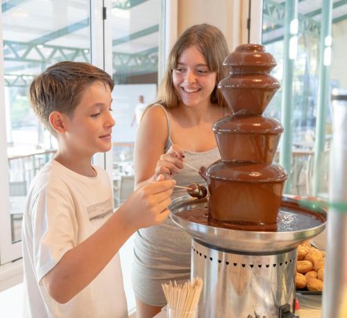 a woman and a young boy standing next to a chocolate fountain at Seth Mestral & Llebeig in Santo Tomás