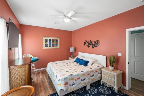 - une chambre avec des murs orange, un lit et un bureau dans l'établissement Sun Soaked, à Gulf Shores