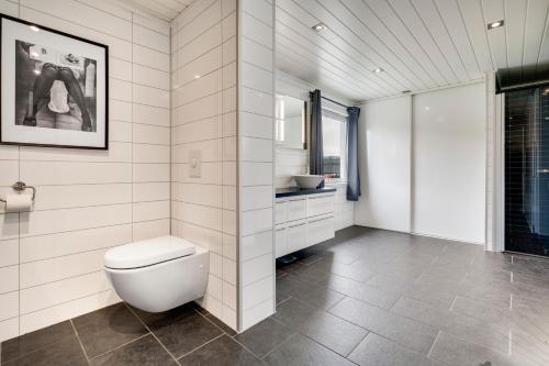 een witte badkamer met een toilet en een wastafel bij Mosjøen Apartments Sentrum in Mosjøen