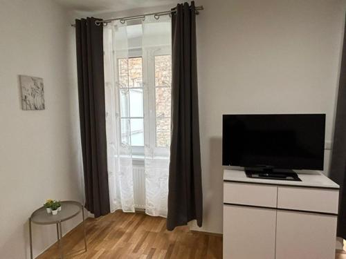 a living room with a television on a dresser with a window at Paky Appartements 00313 in Bruck an der Leitha