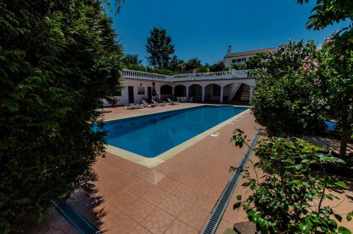 a swimming pool in front of a house at Quinta das Camélias in Tremês