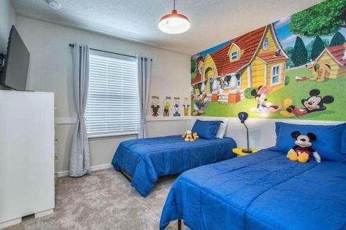 ein Schlafzimmer mit 2 Betten und einem Wandgemälde in der Unterkunft Lovely 5BR4BA w Private Heated Pool BBQ Grill in Kissimmee