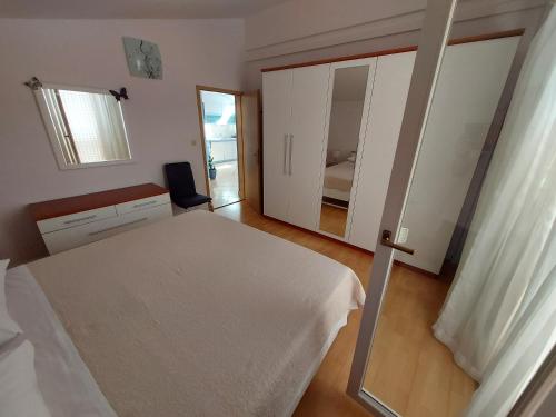 a bedroom with a white bed and a mirror at Apartments Prgin in Primošten