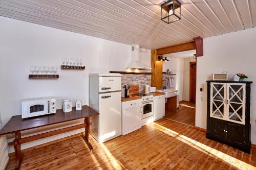 a kitchen with white appliances and a wooden floor at Ritterstube - Eifelstuben mit Charme, Nähe See und Burg, außergewöhnlich, Vulkaneifel in Ulmen