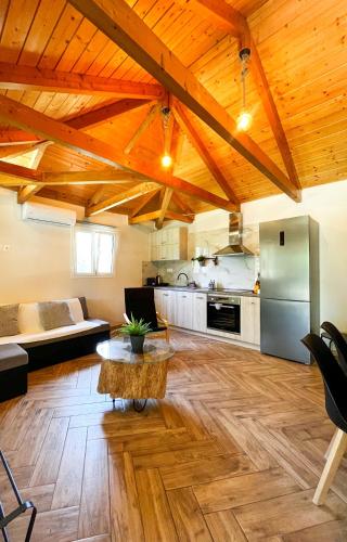 a living room with wooden ceilings and a kitchen at Elleria's House in Lefkada Town