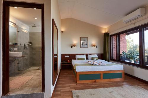 ein Schlafzimmer mit einem Bett und ein Badezimmer mit einer Dusche in der Unterkunft Dhulikhel Lodge Resort in Dhulikhel