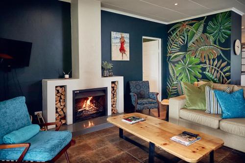 a living room with a couch and a fireplace at The Aloes Farm - The Studio & The Gallery in Hilton