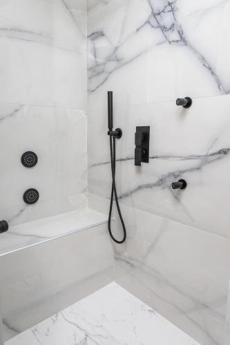 a bathroom with a shower with white marble at simos luxury apartments in Naxos Chora