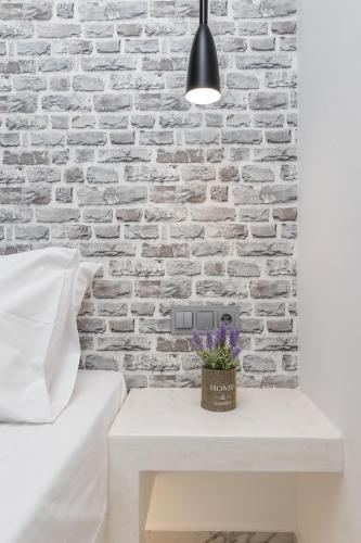 a bedroom with a white brick wall and a white table at simos luxury apartments in Naxos Chora