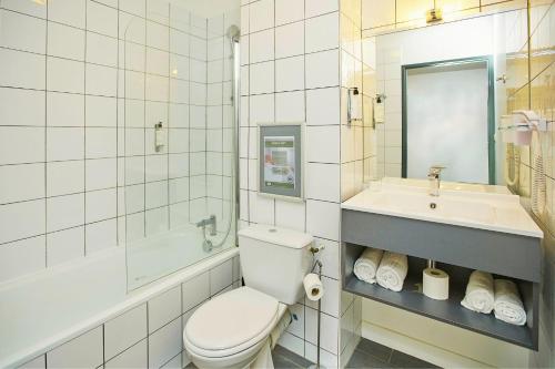 uma casa de banho branca com um WC e um lavatório em Sporting House Hôtel em Toulouse